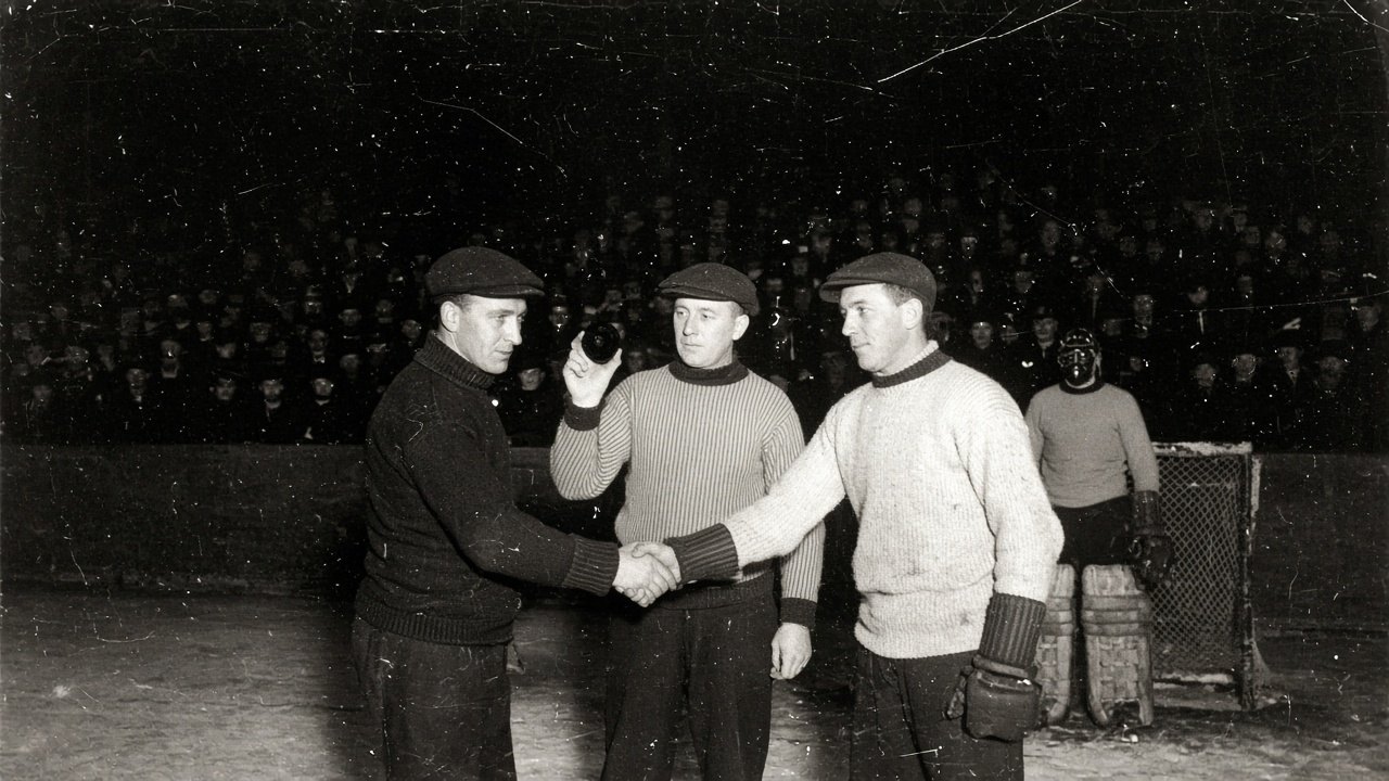 1920s flash photograph of two captains shaking hands at center ice with the referee holding the puck